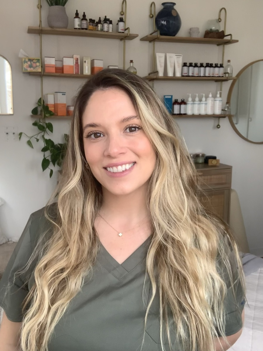 Brittany Franco smiling in front of the studio's product shelves