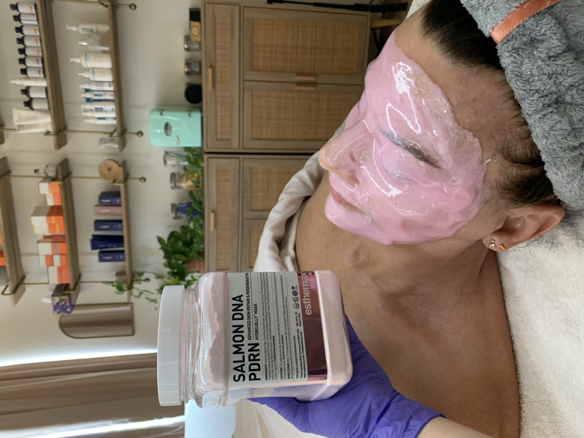 Brittany applying a pink hydrojelly masque during a facial